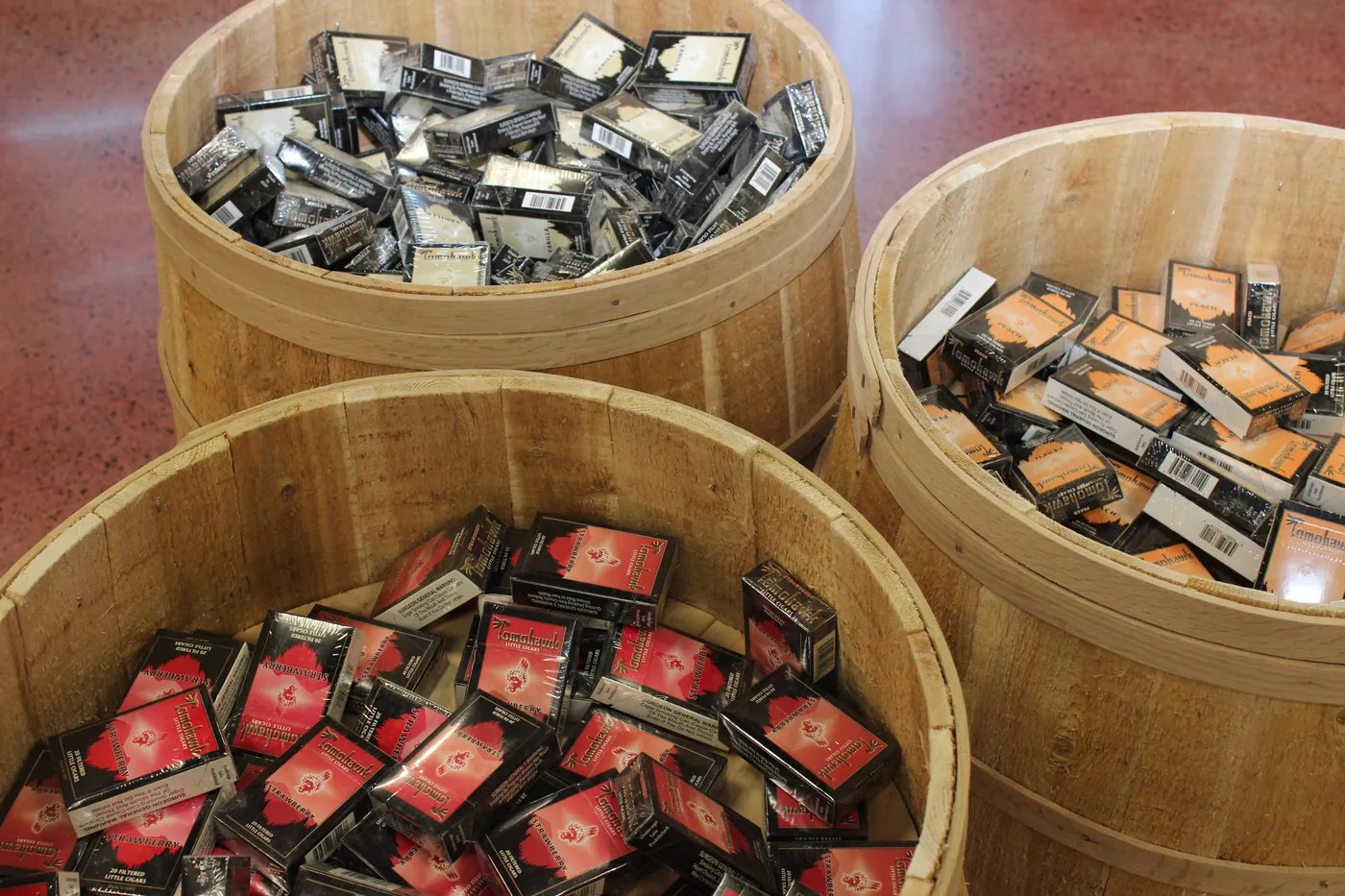 Three wooden barrels on the shop floor filled with loose packaged singles to pick through