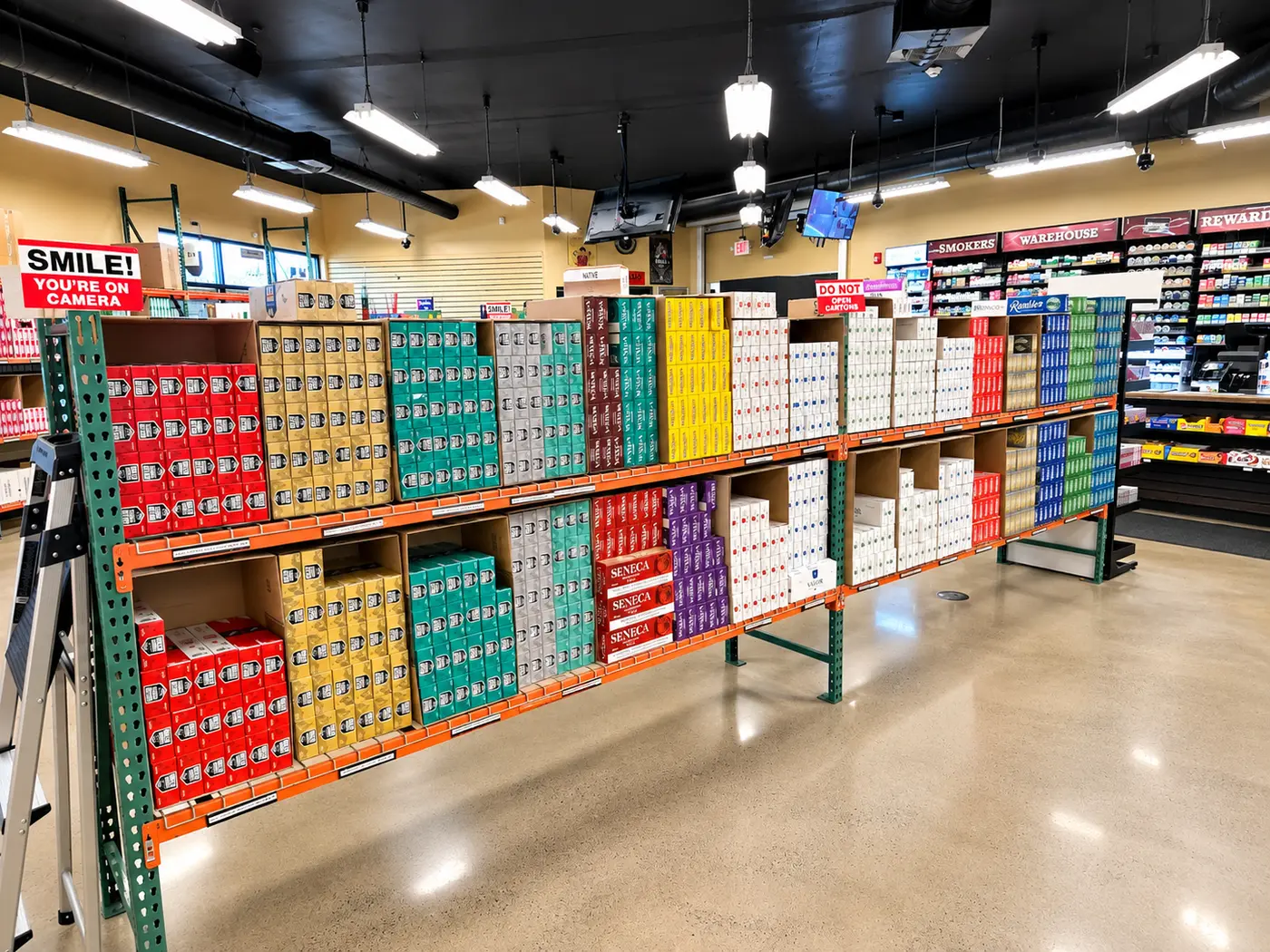The carton wall seen down its length, two tiers of bays filled front to back, with the counter beyond