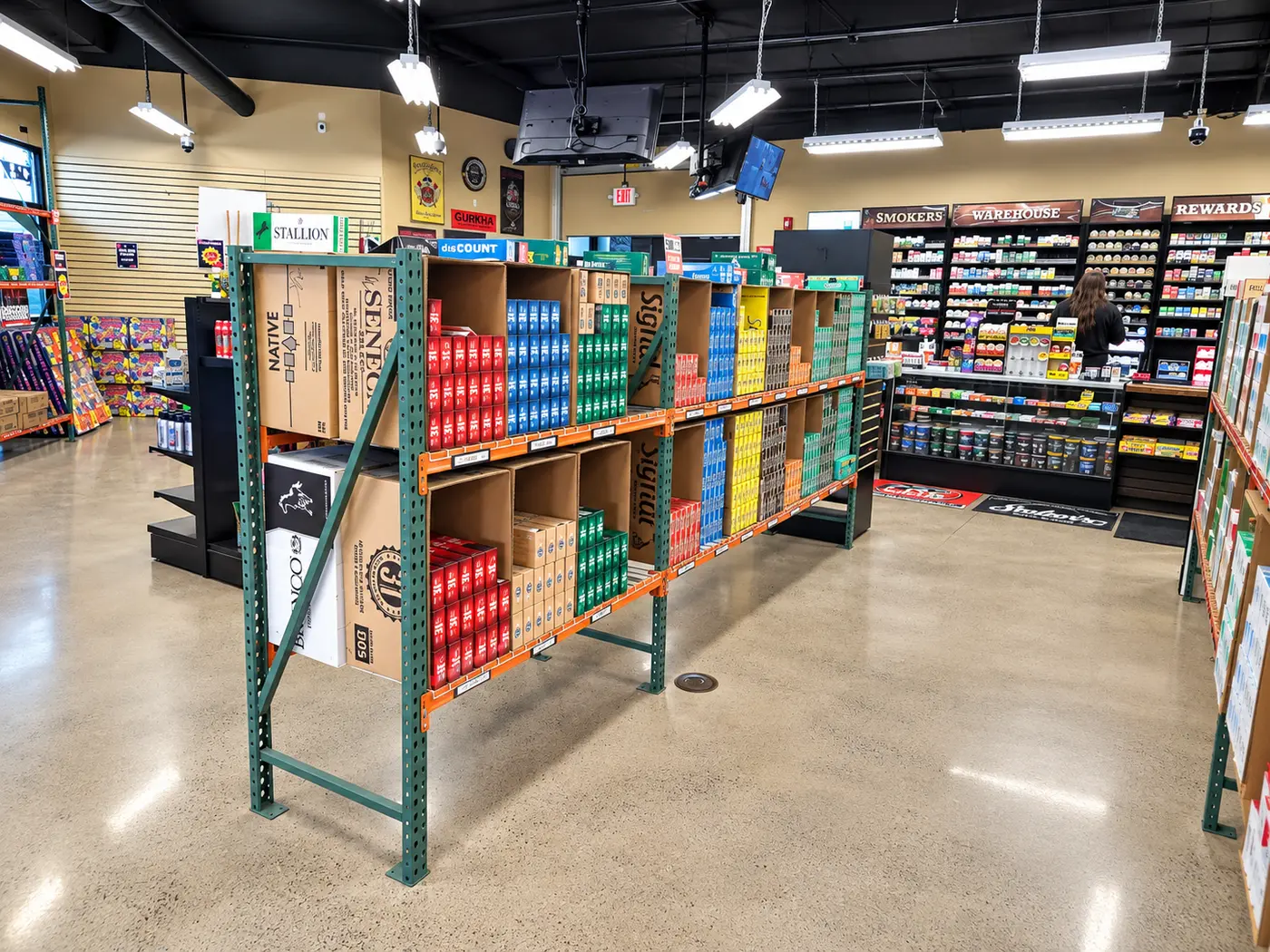 The shop floor looking toward the counter, a carton gondola in the foreground and the wall of tins and pouches behind